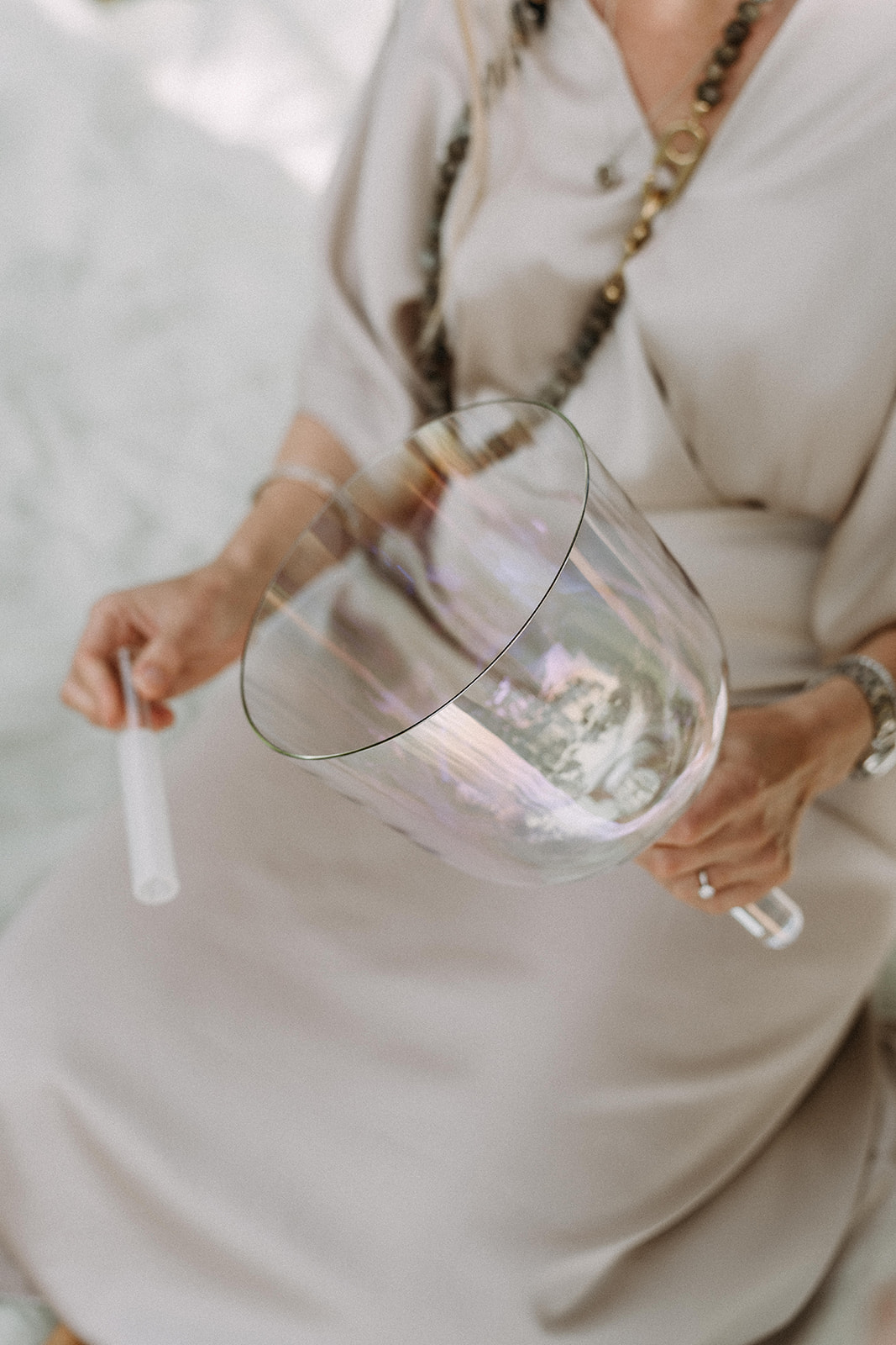 Päivi holding a crystal singing bowl and mallet