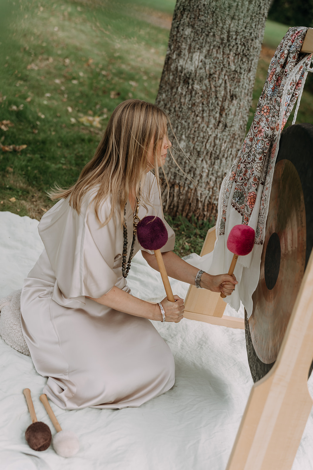 Päivi playing a gong outdoors